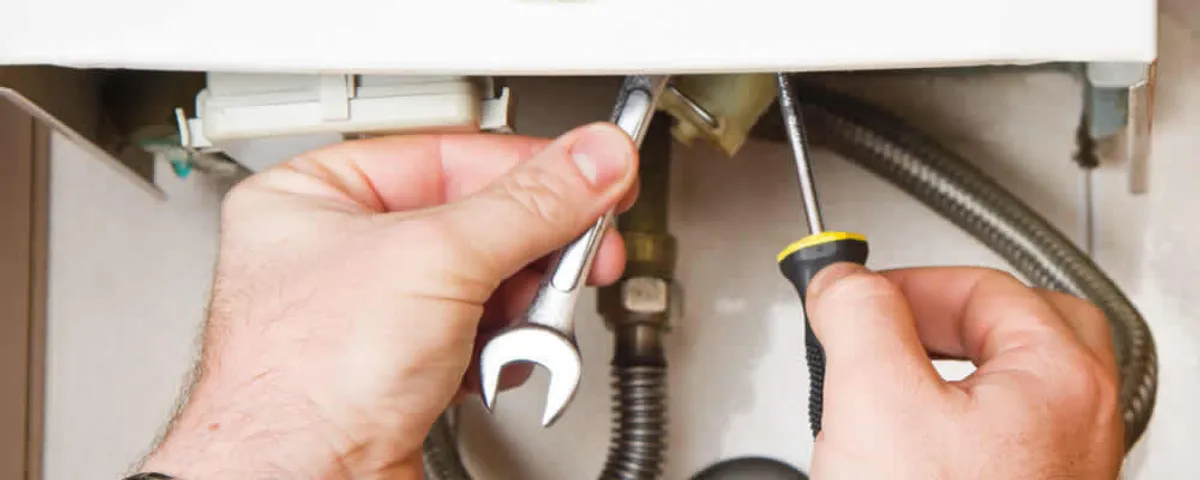 Boiler repair technician tightening pipe fittings and connections in Naperville, IL